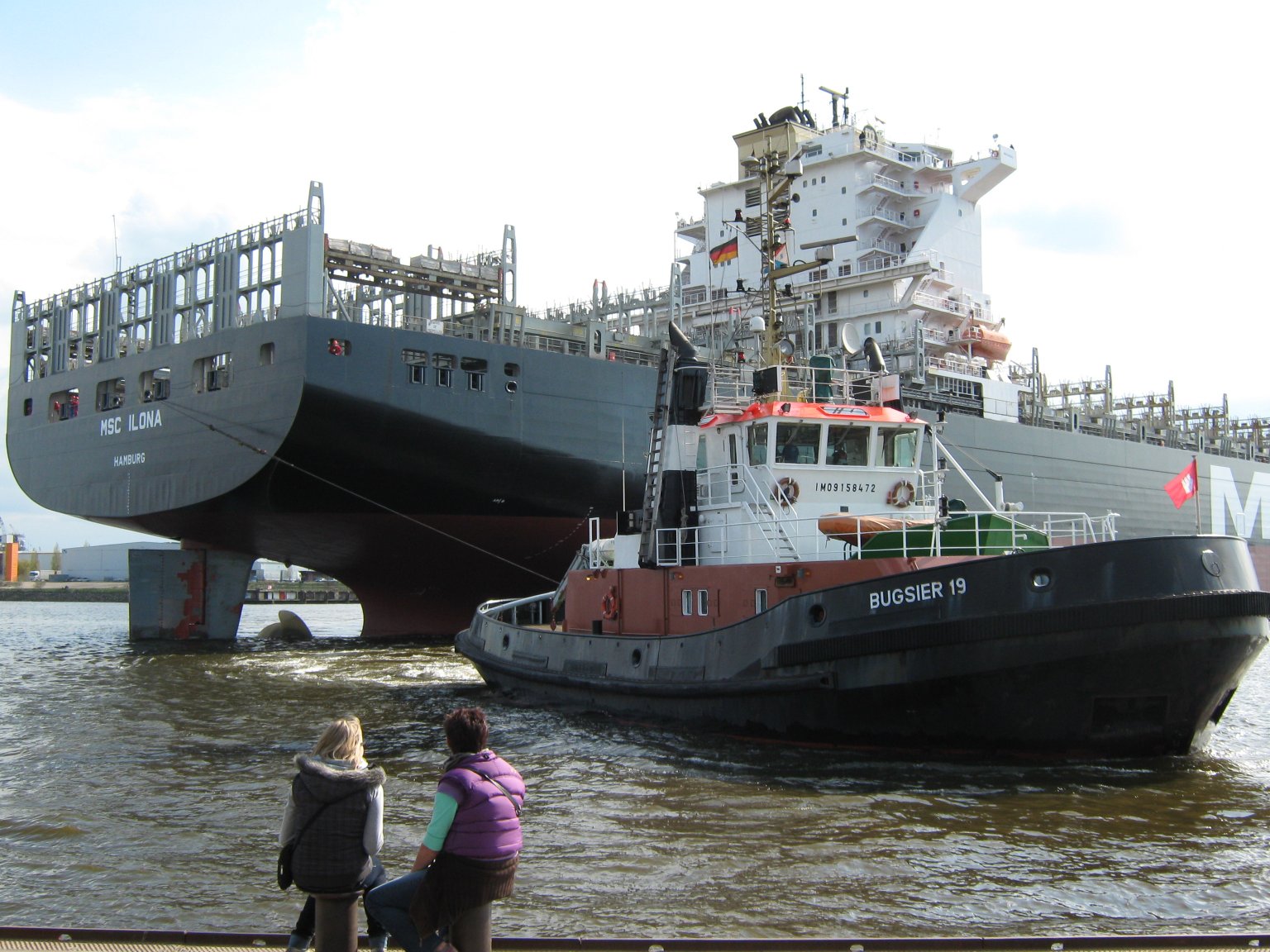 A tugboat manouvering a container vessel, Landungsbrücken